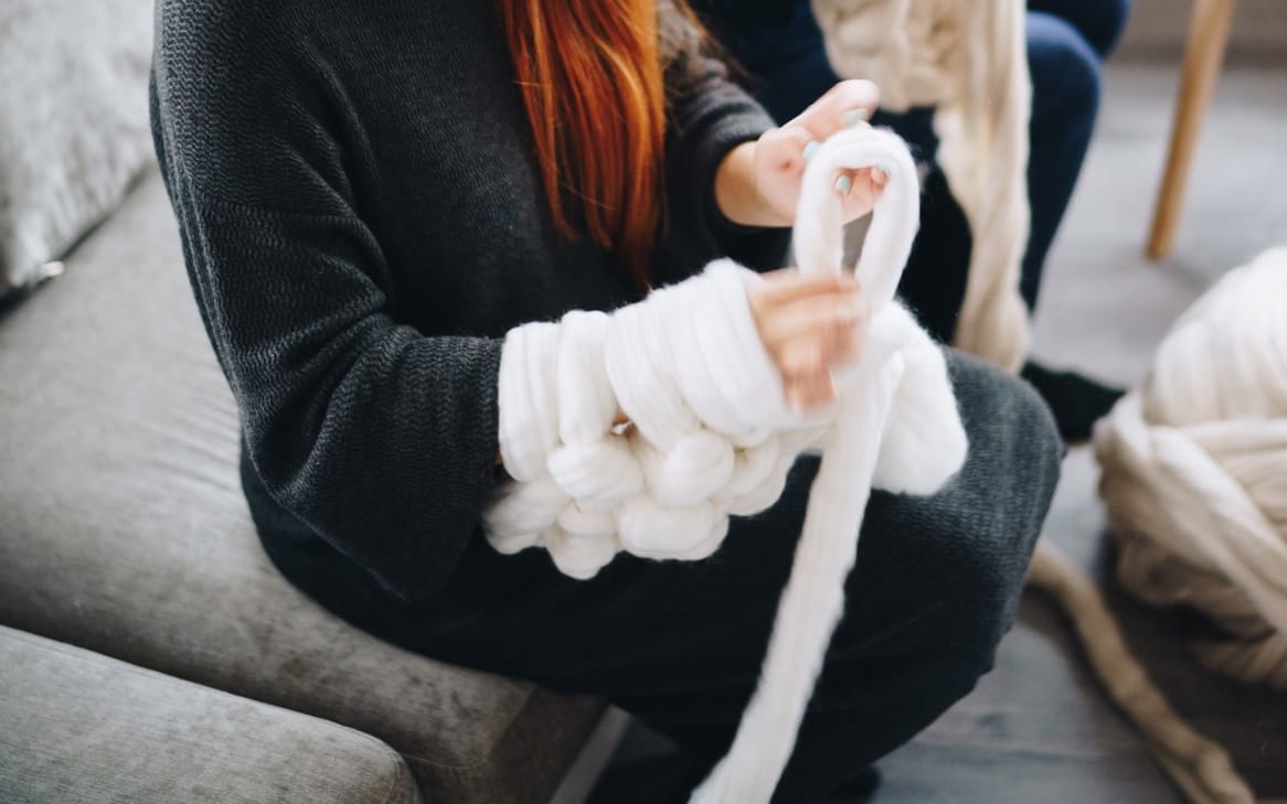 chunky knitting on arms with white chunky knit wool
